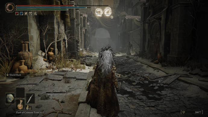 A warrior puts up their shield to defend against magic projectiles ahead in Belurat, Tower Settlement in Shadow of the Erdtree.