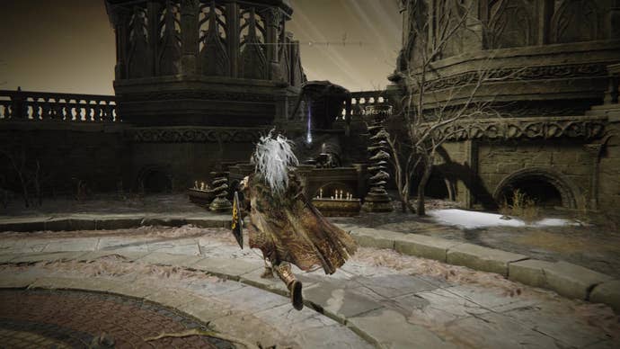 A warrior runs towards a statue in Belurat, Tower Settlement in Shadow of the Erdtree