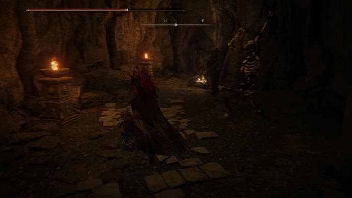 A warrior braces for a surprise attack from a skeleton monster in the Dragon's Pit in Shadow of the Erdtree