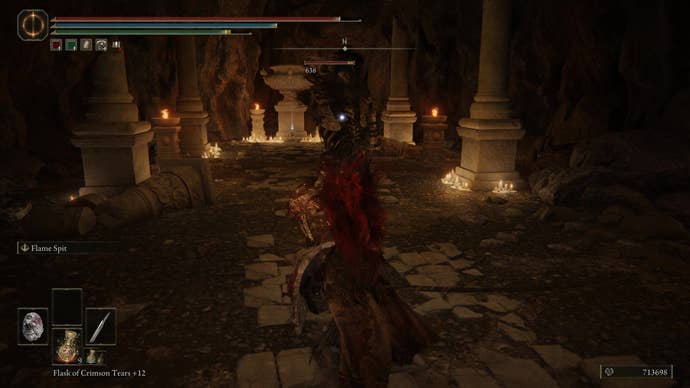 A warrior fights a skeleton monster in an underground cave in the Dragon’s Pit in Shadow of the Erdtree