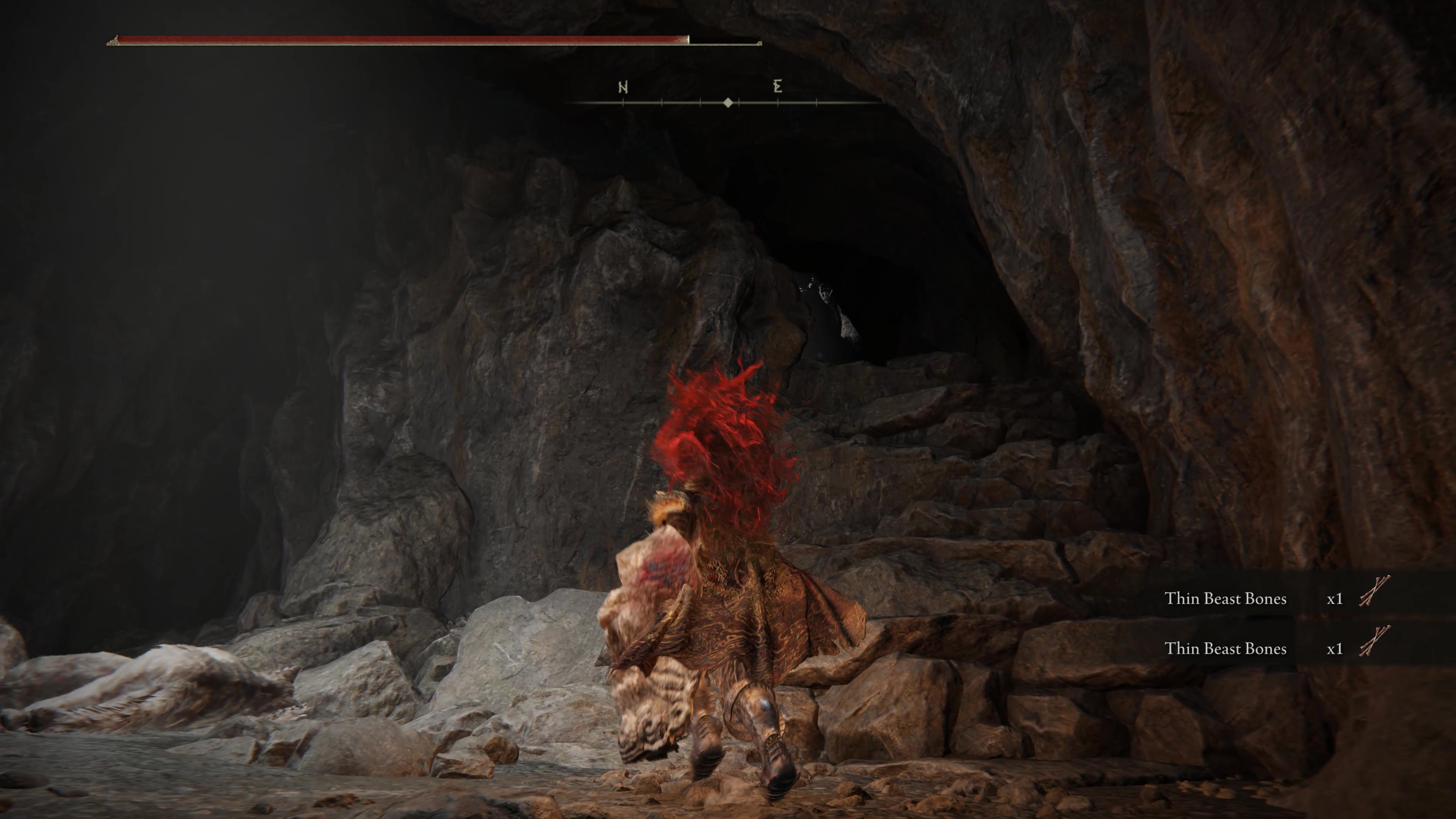 A warrior jumps up some rocky steps inside  the Rivermouth Cave in Shadow of the Erdtree.