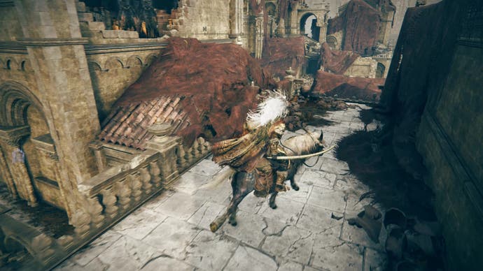 A warrior rides a horse on a series of buildings draped in red cloth in Shadow of the Erdtree