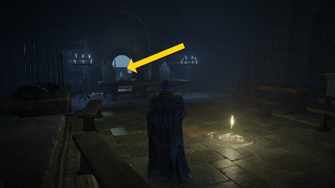 The player in Elden Ring: Shadow Of The Erdtree stands in a dark room next to a Site Of Grace. A yellow arrow points towards a doorway onto a balcony.