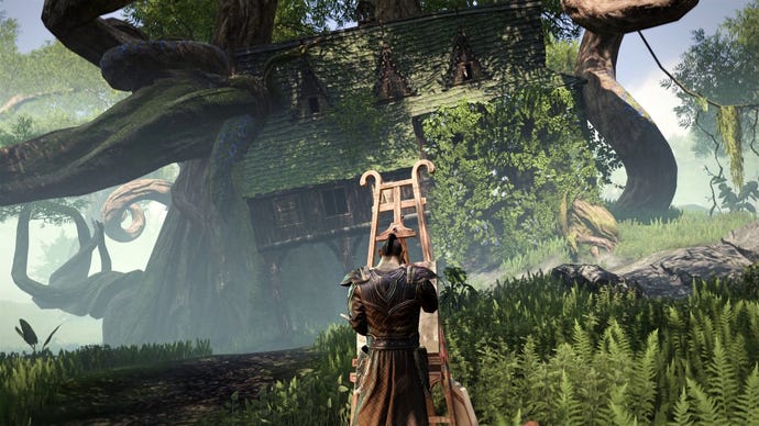 An artist paints a house uprooted into the sky by a massive tree in the Gold Road chapter of The Elder Scrolls Online