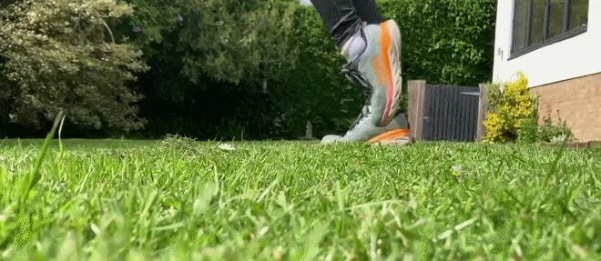 An animated gif of Emma jogging on the spot in her garden. All you can see are her grey and orange trainers going up and down on grass.