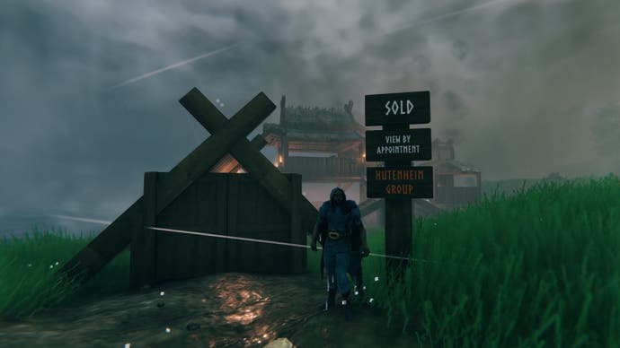 A viking man stands in front of a wooden fence and sign, which declares the property, slightly visible in the dense fog behind it, has been sold.