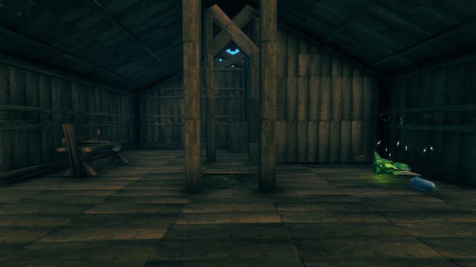 The inside of a Viking log-built hall. It is drab and dreary, with no torches for light and furnishings for comfort.