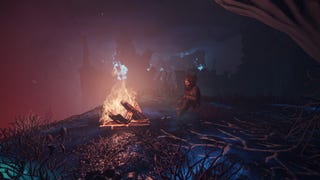 A player in Enshrouded sits beside a campfire at night.