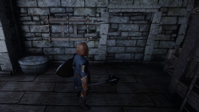 The player in Enshrouded looks at a fake wall in a building.