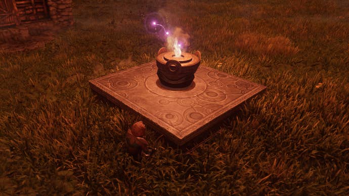 The player in Enshrouded sits down beside their Flame Altar in the grass.