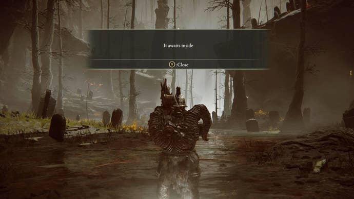A heavily armoured player turns to the camera as a message says “It waits inside” flashes above their head in Elden Ring: Shadow Of The Erdtree.