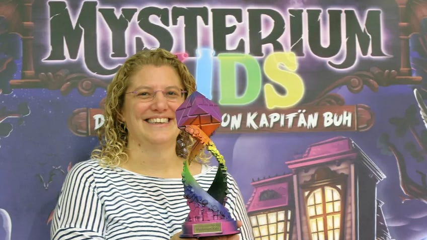 Mysterium Kids designer with trophy at Essen Spiel 2023