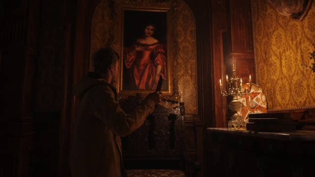 Ethan by a candle in Resident Evil Village third person