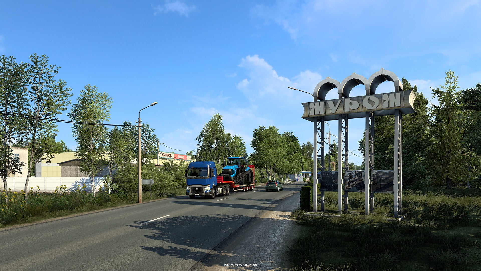 A screenshot of Euro Truck Simulator 2&rsquo;s coming Heart Of Russia DLC showing a lorry with a tractor on its back driving past the metal entrance sign to a city.