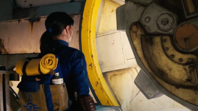 An image from the Fallout TV series trailer showing a Vault Dweller, played by Ella Purnell, waiting as a Vault door opens.