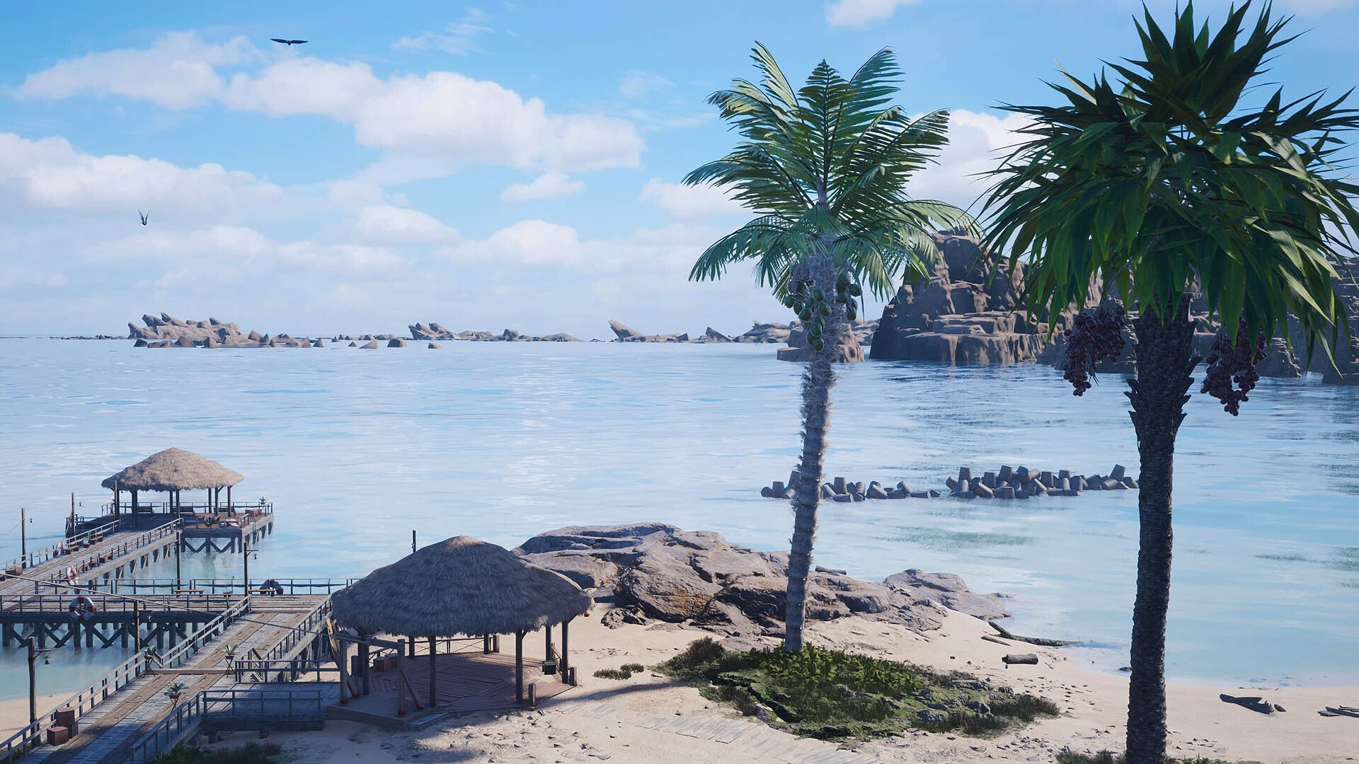 There are straw huts sitting on a pier on a sandy beach, the ocean is blue and calm behind them with two palm trees on the right side of the image.