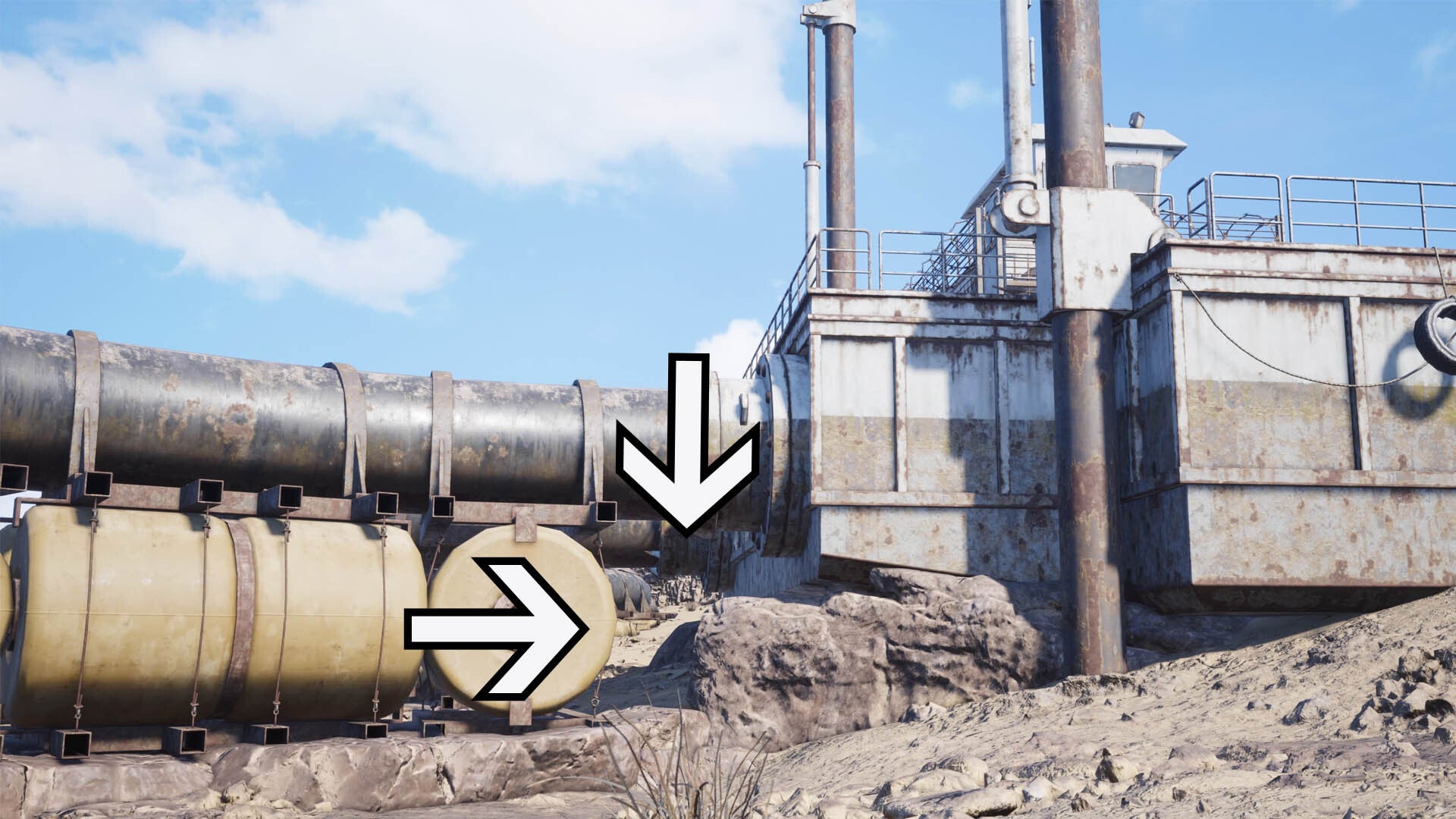 Two arrows point to a gap underneath a large pipe connecting to a control unit in the desert.