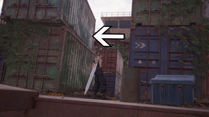 An arrow points to the left of the screen showing the exit point between large ship containers that Cloud is standing between.