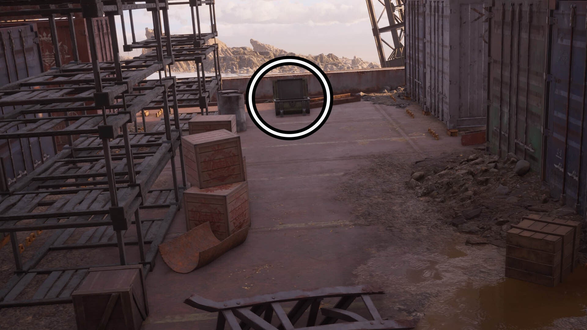 A circle highlights an open reward chest on the deck of an abandoned ship, it&rsquo;s next to some old metal shelves and large shipping containers.