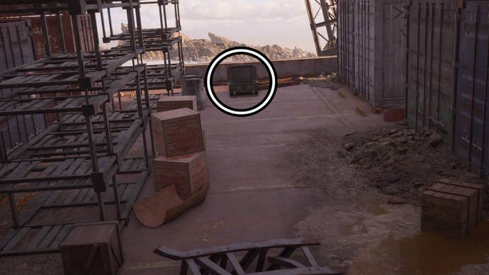 A circle highlights an open reward chest on the deck of an abandoned ship, it’s next to some old metal shelves and large shipping containers.