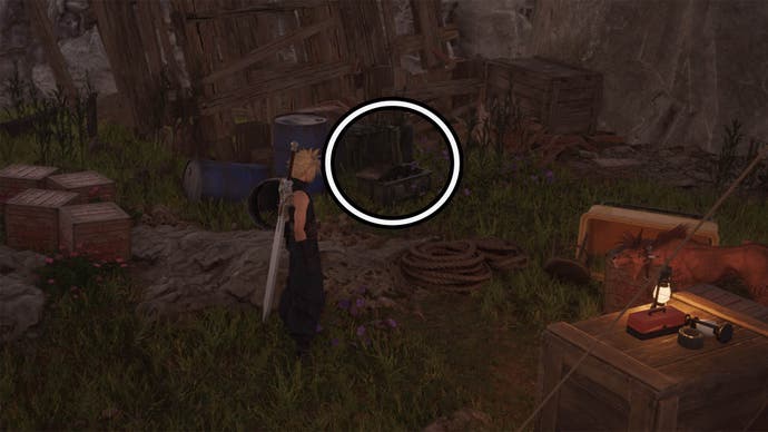 A circle is highlighting an open reward chest beneath a haphazard wooden structure, it's hidden amongst some other crates as Cloud stares at it.