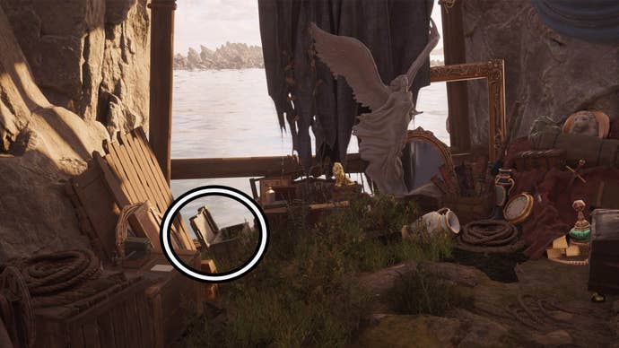 A circle highlights an open reward chest to the left of a large winged statue, it’s among numerous items of treasure including bottles and gold.