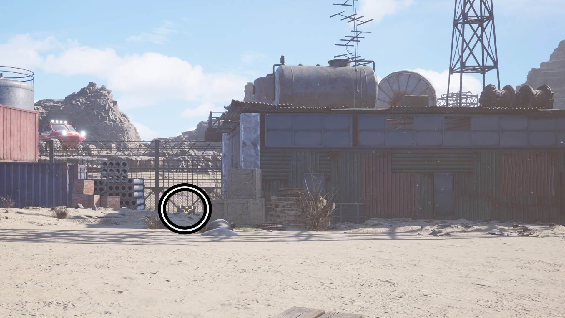 A circle highlights a reward chest towards the left of the image beside a shack that&rsquo;s been boarded up with metal sheets.