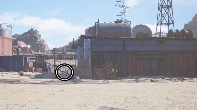 A circle highlights a reward chest towards the left of the image beside a shack that's been boarded up with metal sheets.