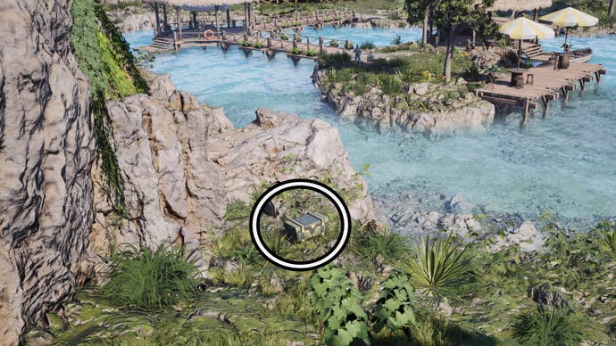 A circle highlights a reward box sitting in some green foliage, a wooden pier with parasols on it sit in the background.