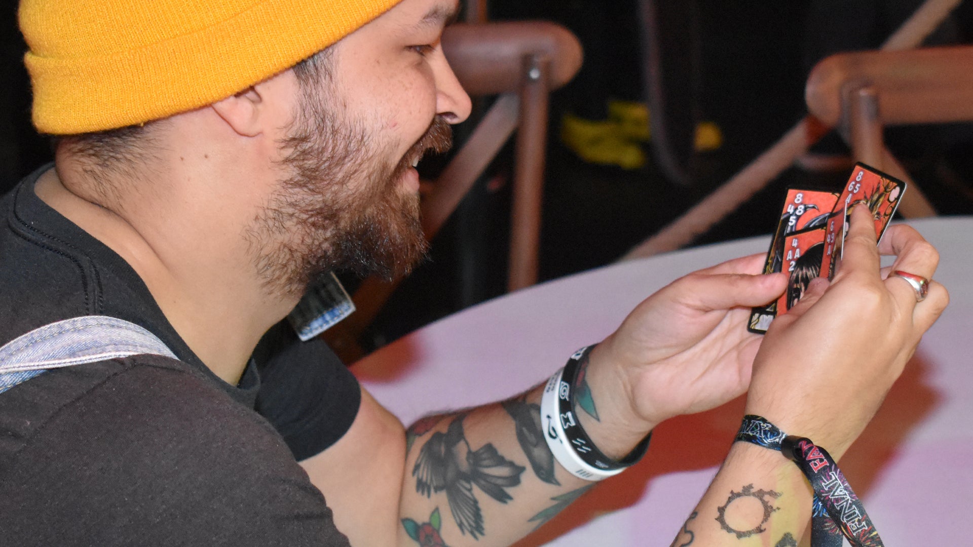 Player Matt smiling and arranging a hand of Triple Triad cards at Final Fantasy Fan Fest