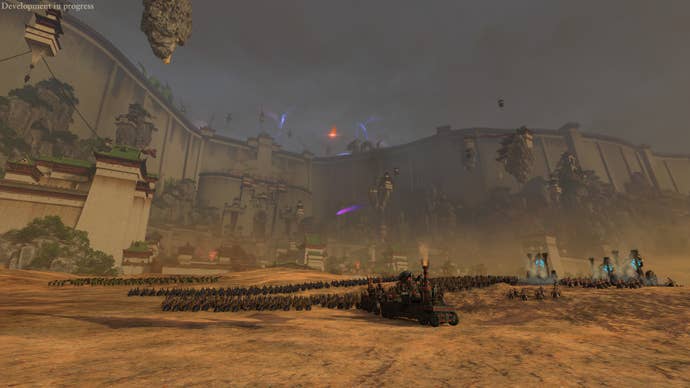 An army of orcs camped outside the great walls of a city in Total War: Warhammer III’s Forge Of The Chaos Dwarfs DLC