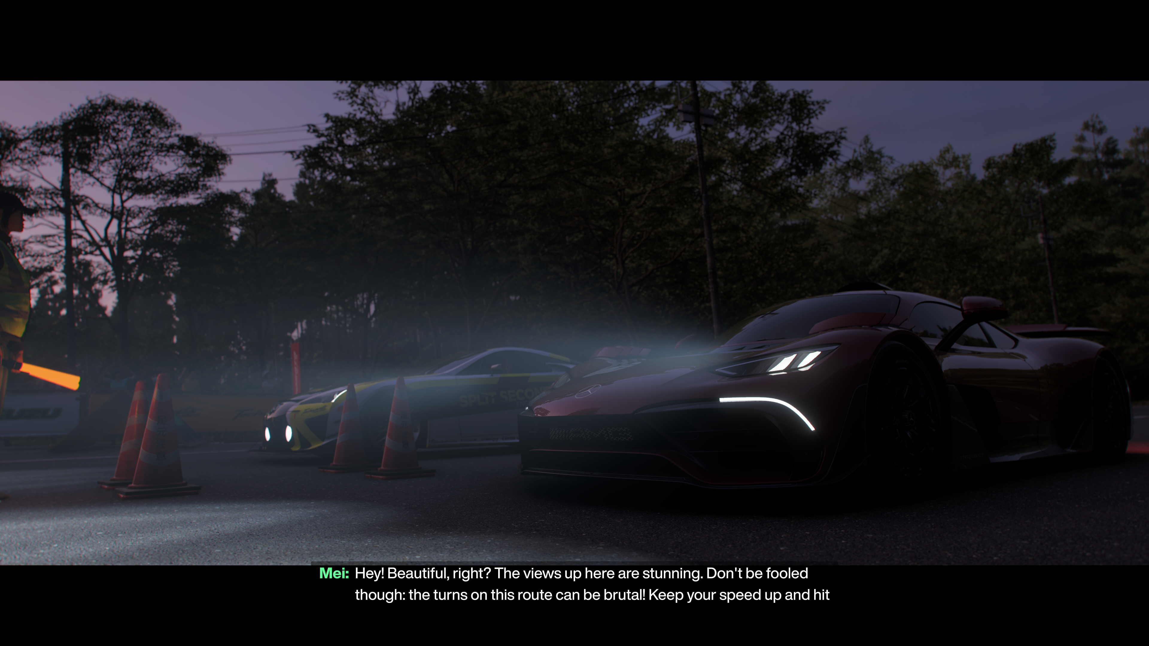 Night shot; two cars lined up on a startline with headlights showing through light fog, trees in the background