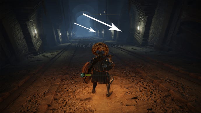 A corridor with a deadly wagon inside the Fringefolk Hero’s Grave in Elden Ring.