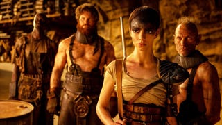 Furiosa stood in a cave with three men stood behind her.