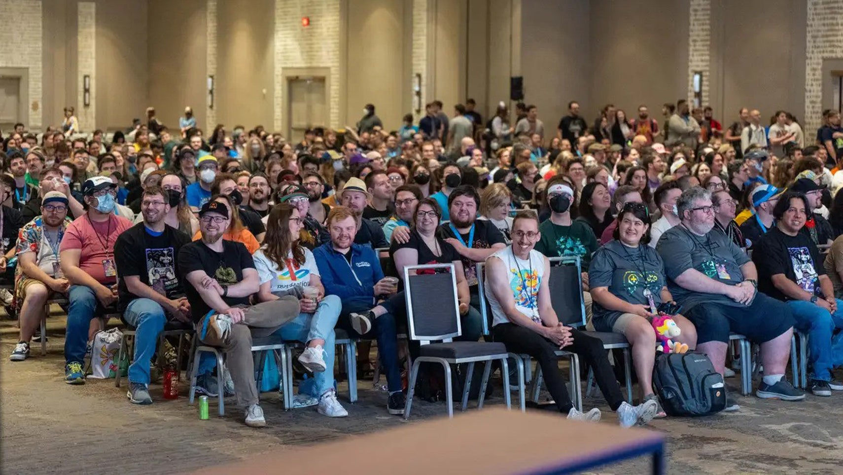 A large number of people sat in a room facing the same direction. - 1