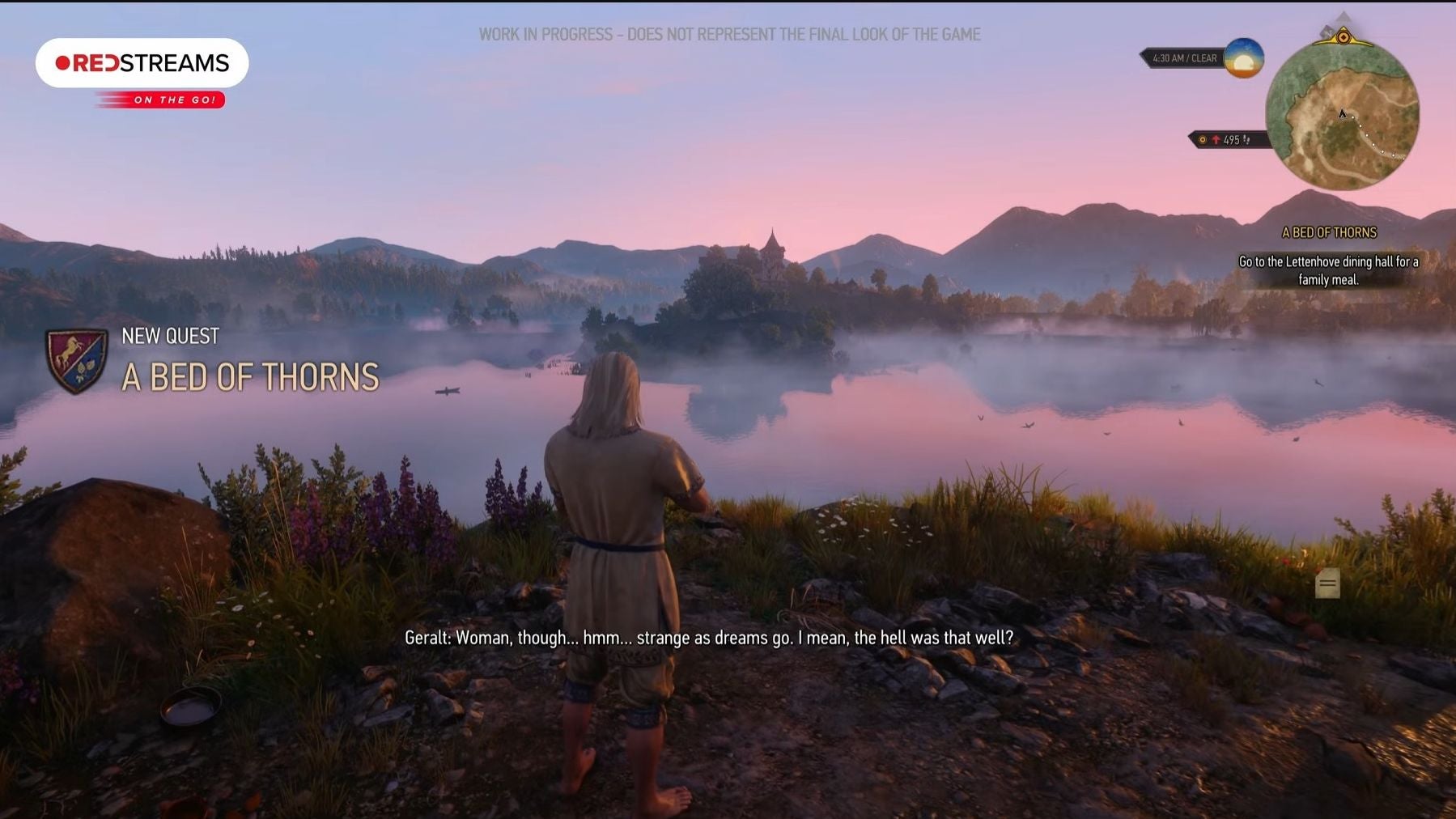 A white haired man stands on the edge of a river in the morning light.