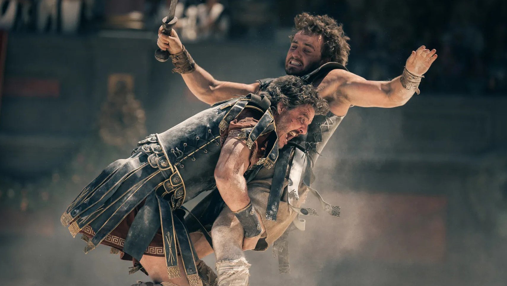 Two men, Pedro Pascal and Paul Mescal, in ancient Roman outfits, Pascal tackling him in Gladiator 2. - 1
