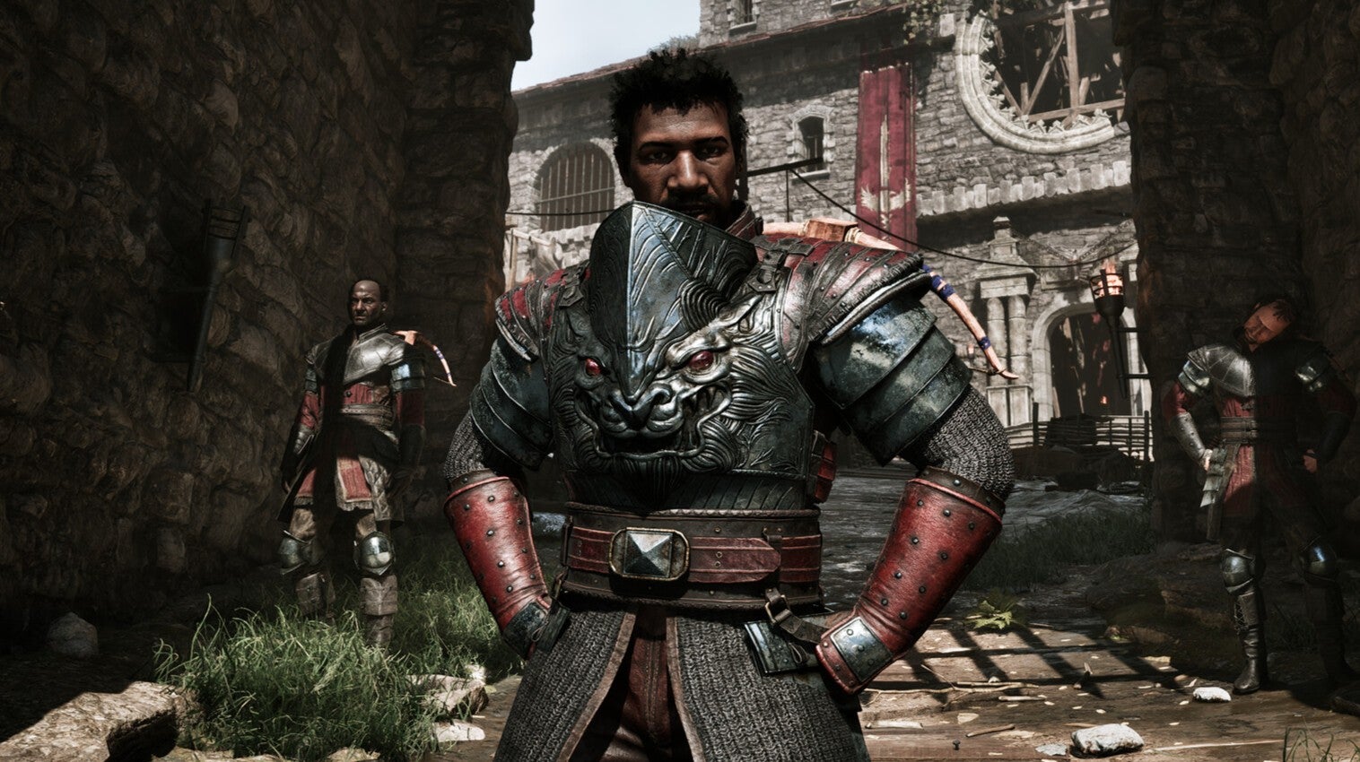 A Black man in ornate metal armour with his hands on the hips, standing in front of an arched entrance to a town in the Gothic remake.