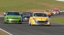 Cars racing on a track with grass either side. In order from the front: yellow, green, black, orange, red.