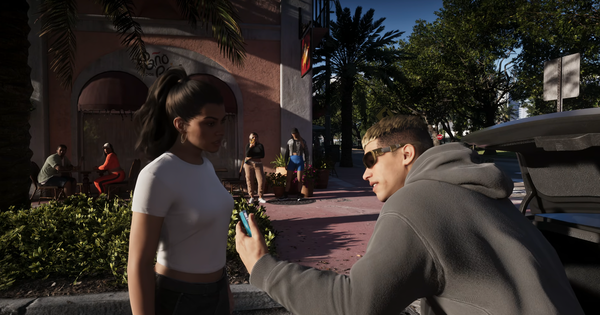 Photo: Eurogamer Grand Theft Auto 6 man holding his smartphone and chatting into it while Lucia looks on, unimpressed
