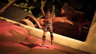 A tiny human character jumps with their arms held up in the air, as if in celebration, while behind them, the steering wheel of a huge car and a huge muscular toy man - in reality a tiny toy man but we're seeing this from the perspective of a shrunken person - can be seen. It's Grounded 2.