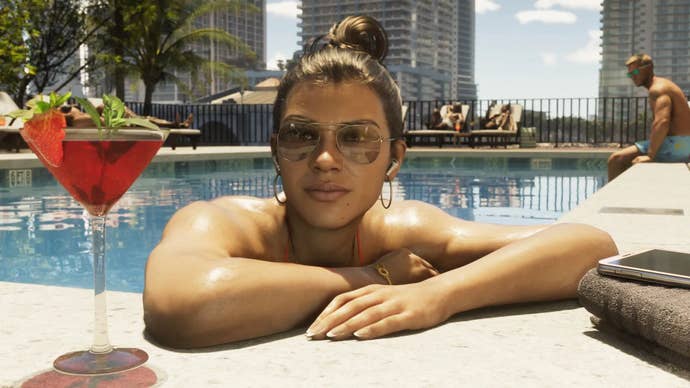 Lucia relaxes by the edge of a pool with a red cocktail, wearing sunglasses.