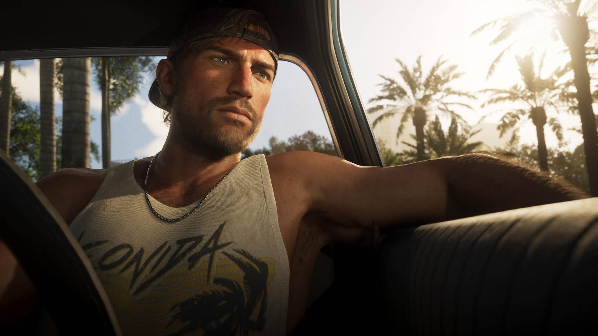 GTA 6 protagonist Jason Duval sitting casually in his car with one arm hanging out the window, palm trees silhouetted in the background against the blinding sun.