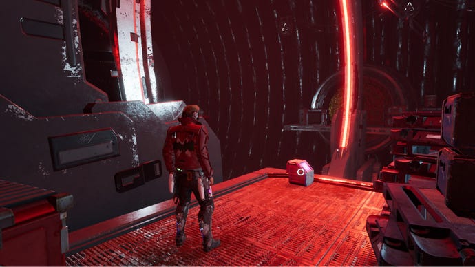 Star-Lord stood on metal walkway near an outfit box with a large red ring in the background