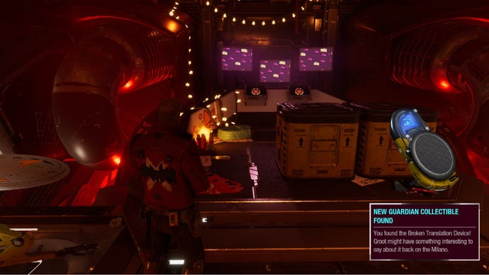 Star-Lord stands in Nikki’s hideout, pink screens up ahead with crates on the floor nearby.