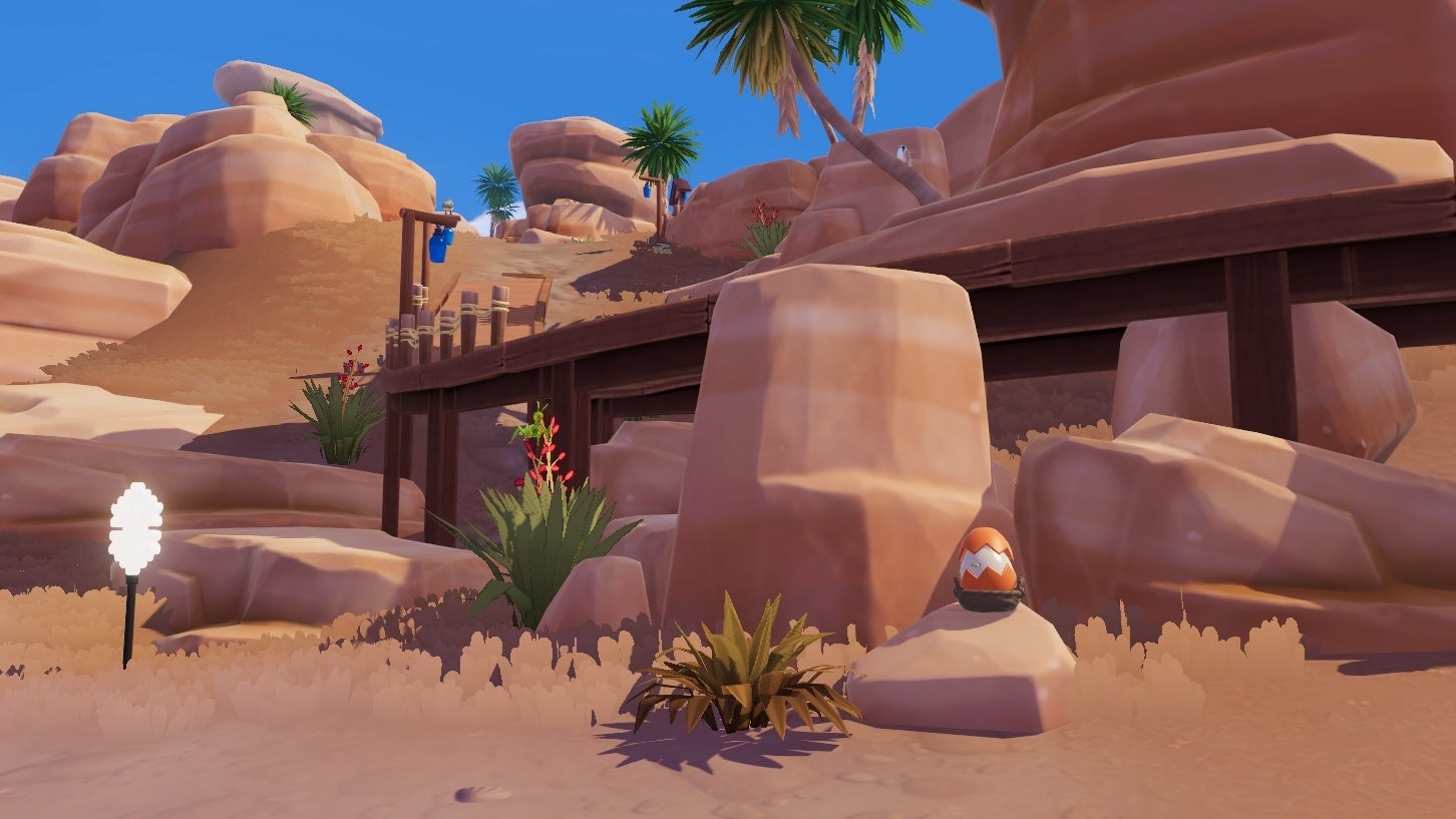 In an orange rocky area in Heartopia, an orange egg sits in a basket tucked between three rocks underneath a wooden walkway. - 12