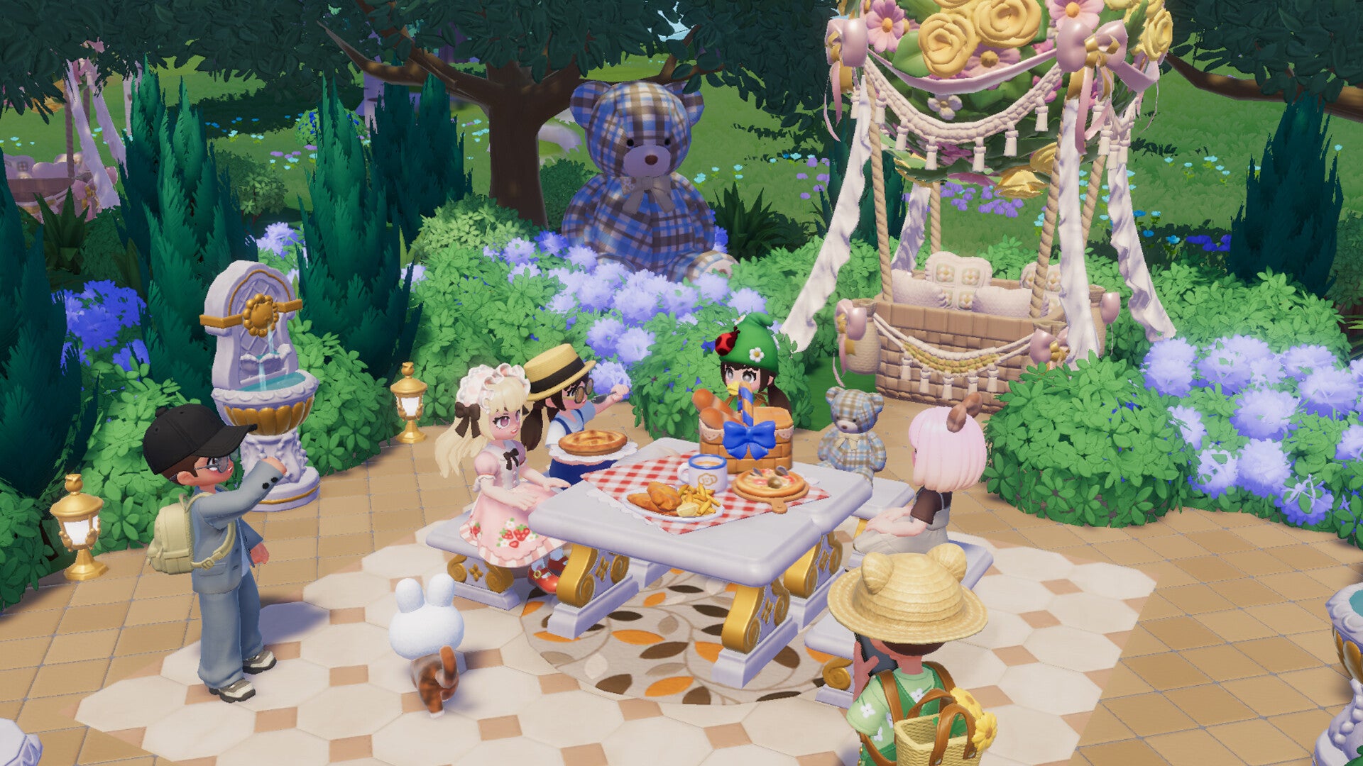 A group of player characters meet for an outdoor dinner party in Heartopia, dining in a Greek-style white-and-gold manicured garden space accompanied by several patchwork teddy bears and with a hot air balloon parked nearby.