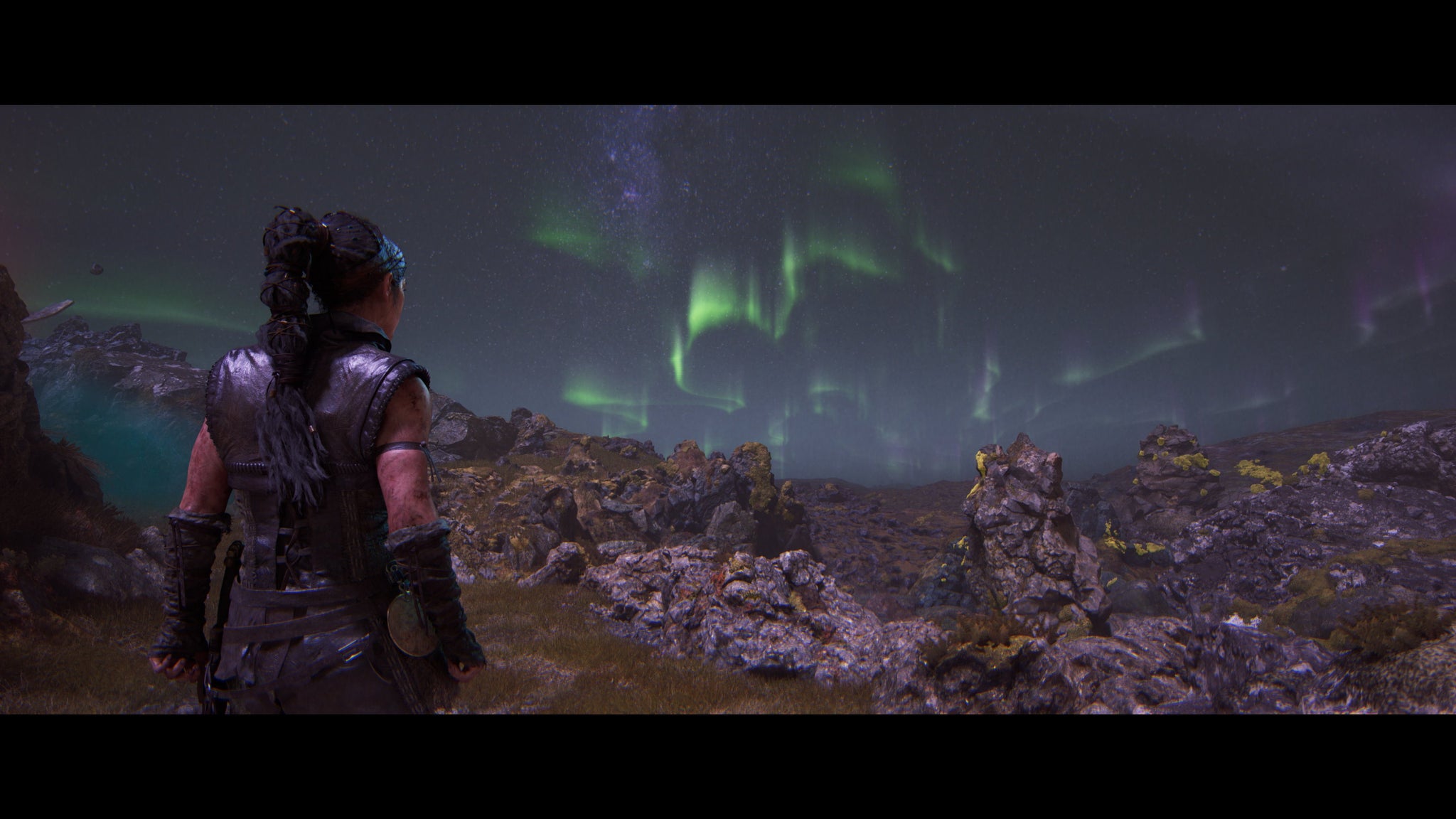 Senua, in Hellblade 2, stares out across the Icelandic scenery to watch the aurora borealis. - 5