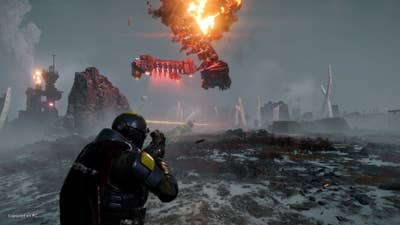 Helldivers 2 screenshot over the shoulder view of a soldier holding a weapon up. A drop ship explodes and falls to the planet surface in the background