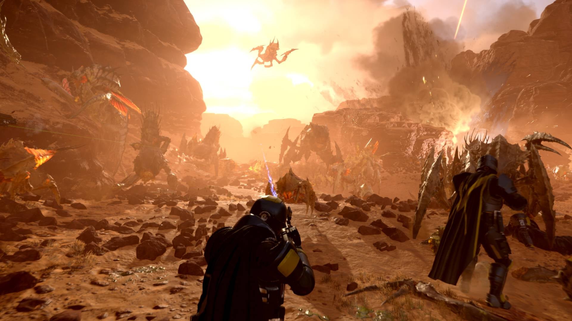 A Helldiver on a rocky planet firing at Terminids in a canyon with another Helldiver fighting a bug up close to the right. - 3